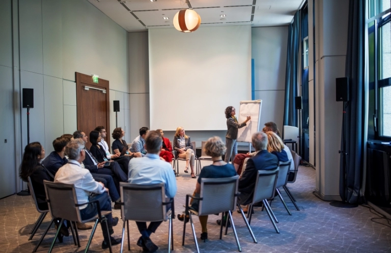 sala pełna ludzi na krzesełkach